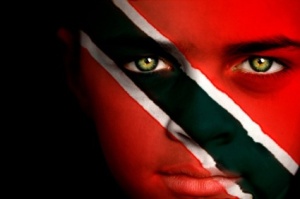Portrait of a boy with the flag of Trinidad and Tobago painted on his face.
